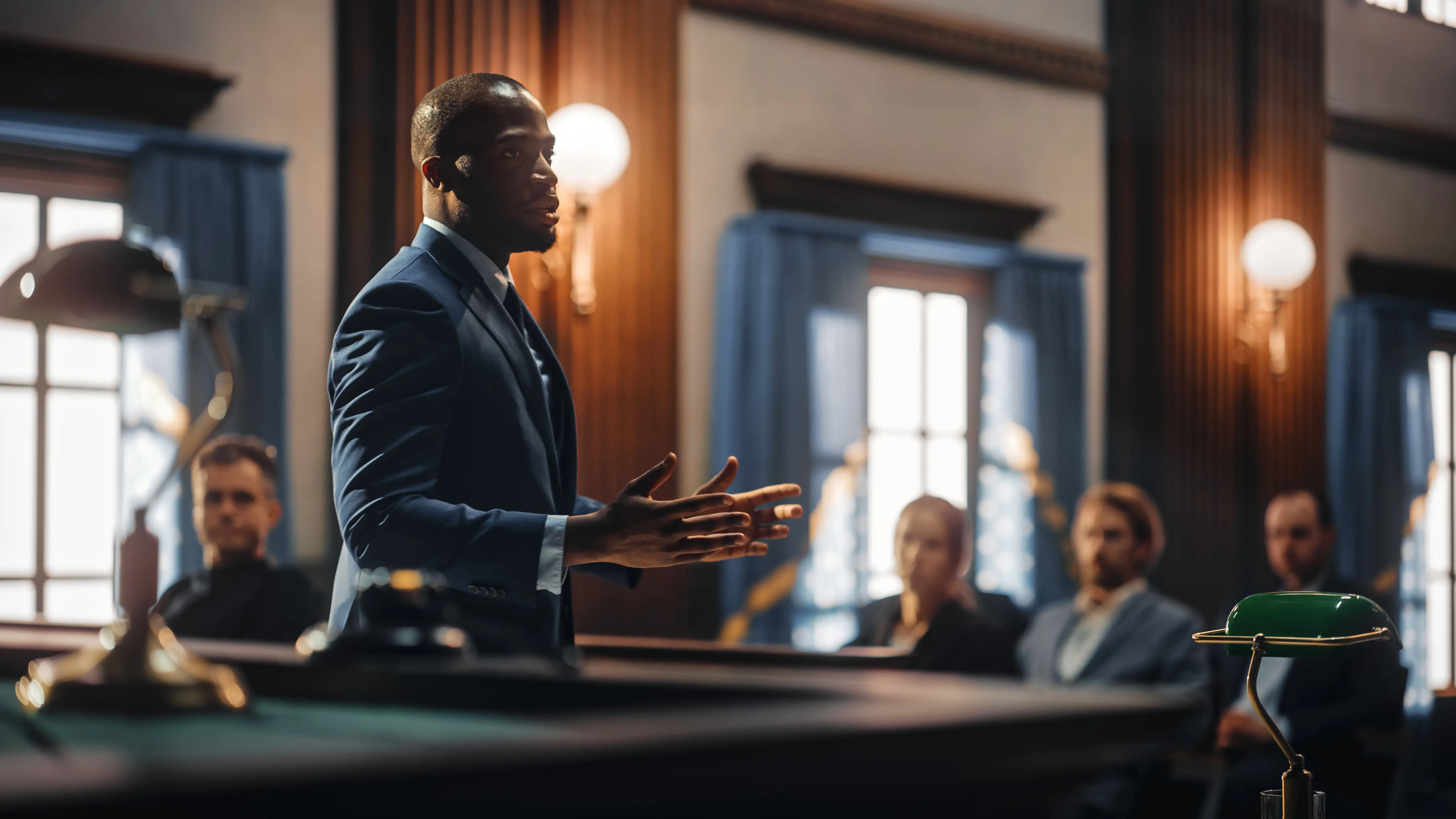 an audience looking at a black lawyer speaking in court